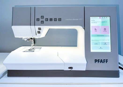 A photo of a beige and white sewing machine with a large, 7” color capacitive touch screen, a bright workspace light and a healthy almost 10” throat space.