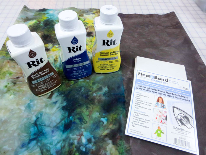 HeatnBond Featherlite Iron-on Adhesive and 3 bottles of Rit dye on a piece of ice-dyed fabric