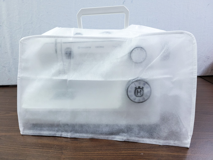 A white dust cover on a sewing machine; Husqvarna VIKING ONYX 25