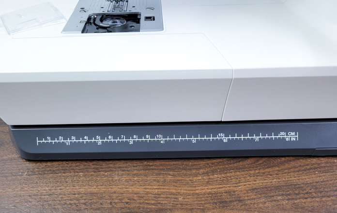 A gray base with white ruler markings on the base of the Husqvarna VIKING ONYX 25 sewing machine
