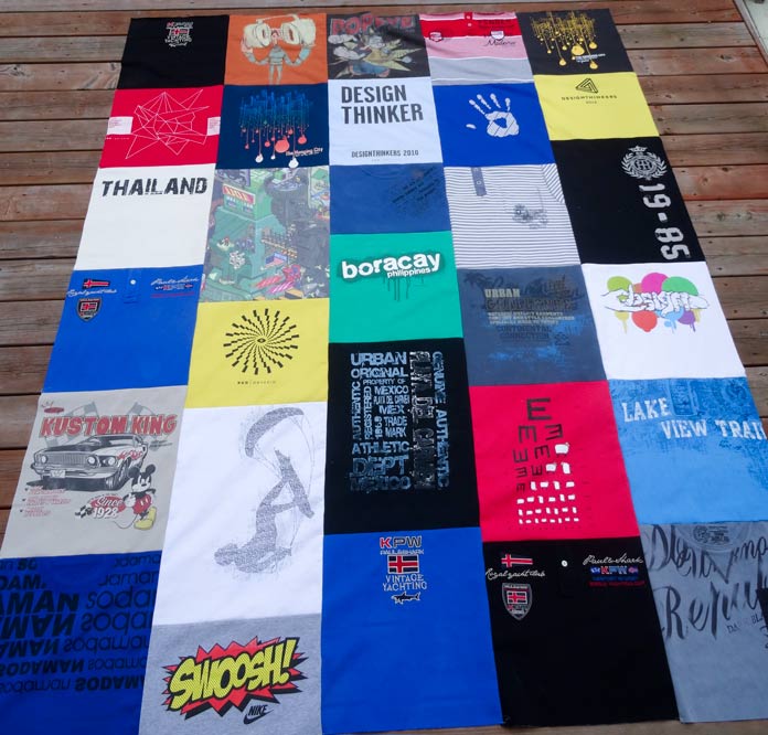A quilt made of 30 multi-colored T-shirts. Each T-shirt was cut in a different length.