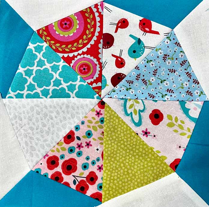 Kaleidoscope Block 2 with 8 colors of triangle pie pieces and turquoise and white corner pieces made with cotton fabric; Free Kaleidoscope Quilt Block Pattern