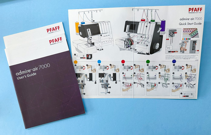 Two white and purple booklets and one laminated page covered in threading guide pictures; PFAFF admire air 7000