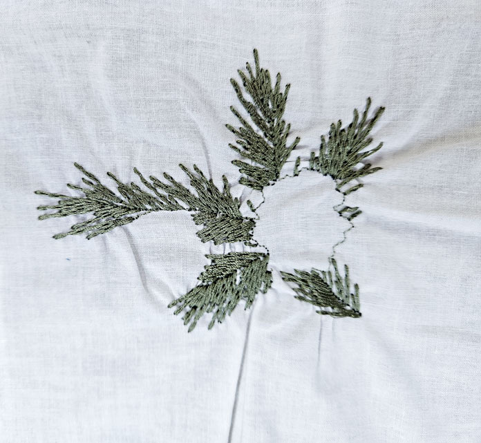 Green stitching on white fabric