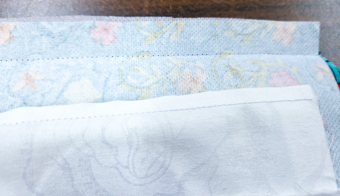 Two white pieces of fabric with two different seam allowances
