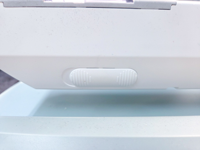 A white slider on a sewing machine