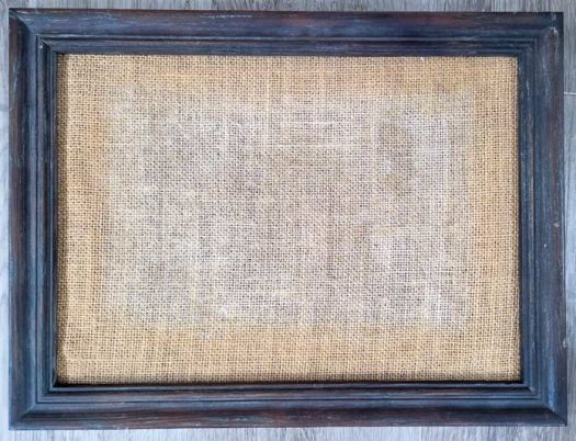 A wooden frame with a burlap background