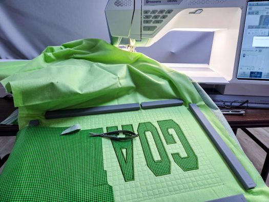 Three green letters on green fabric