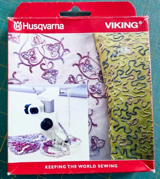 A red and white box with a picture of yarn couching