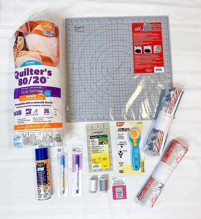 Materials needed to make a Half Rectangle Triangle table runner. UNIQUE sewing Fast Fade Fabric Markers, Gütermann Thread, SCHMETZ Quilting Needles, Fairfield Quilter's 80/20 Batting, Odif 505 Temporary Quilt Basting Adhesive Fabric Spray, Omnigrid rulers, Olfa Rotary Cutter, Komfort KUT Rotary Cutting Mat, Fabric Creations cotton fabric