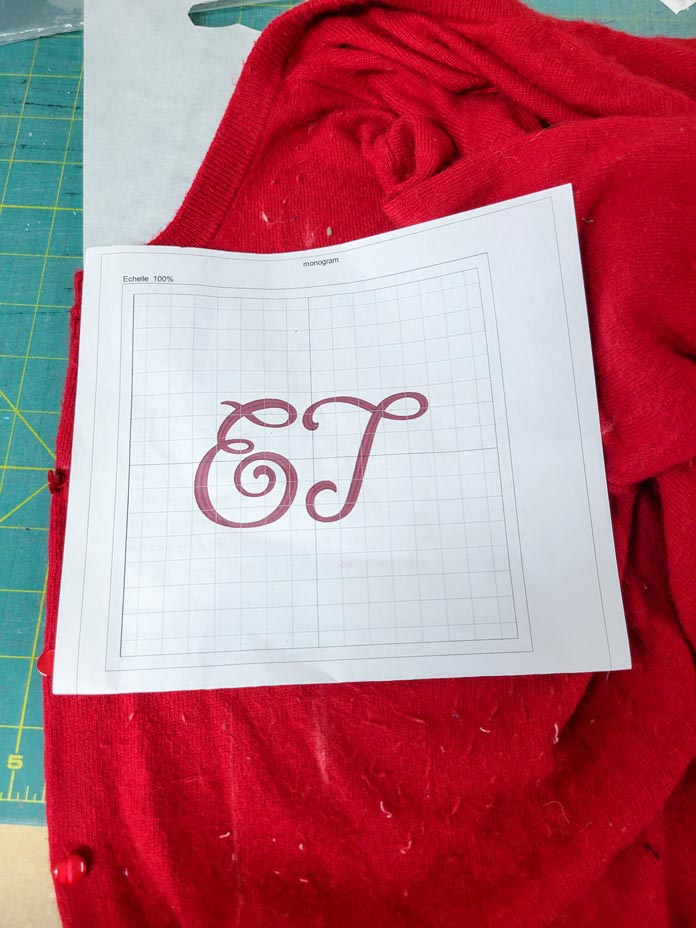 A white paper template with a two-letter monogram on a red sweater