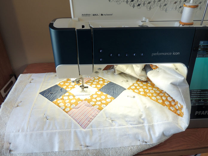 Using a heart template ruler with a sewing machine to quilt a motif on the Spring Table Runner. PFAFF performance icon, Inspira Ruler Foot Template Set