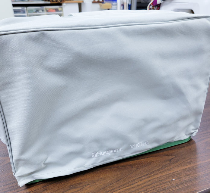 A gray fabric cover for a sewing machine