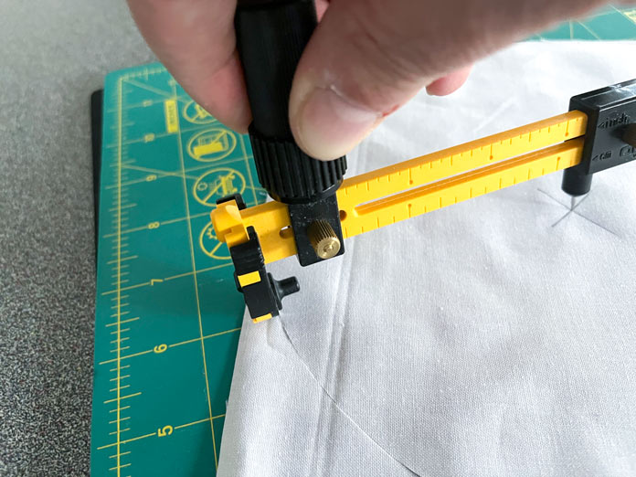 Using the OLFA circle cutter and the OLFA rotating mat to cut a circle on the fabric.