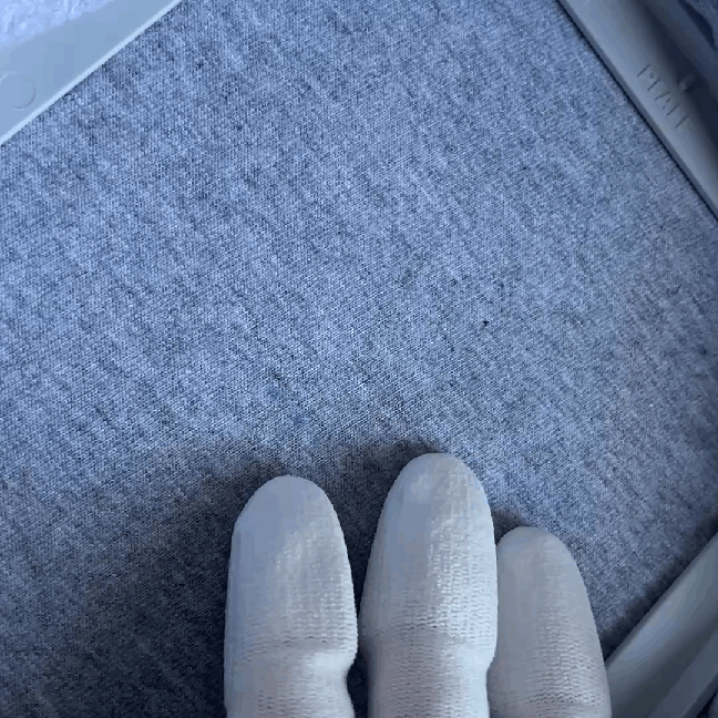 This GIF demonstrates proper hooping technique using the PFAFF 120x120 hoop on a gray T-shirt. A hand wearing a quilting glove gently touches the fabric inside the hoop to show that the fabric is not stretched or taut, helping to prevent puckering or distortion during machine embroidery.