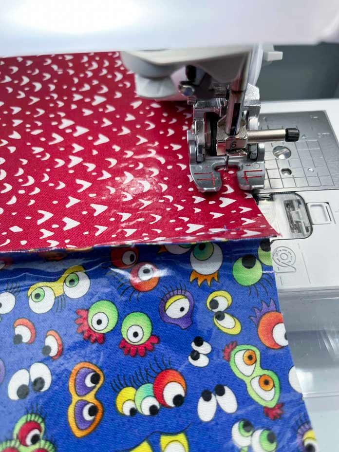 Sewing a red piece of fabric to a piece of blue print fabric