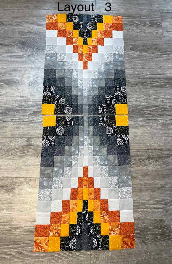 Bargello blocks laid out with orange sections facing inwards to make a table runner