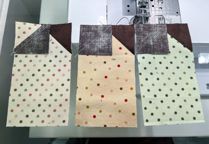 1¾" squares have been sewn to the remaining top corners of the 3" strips.