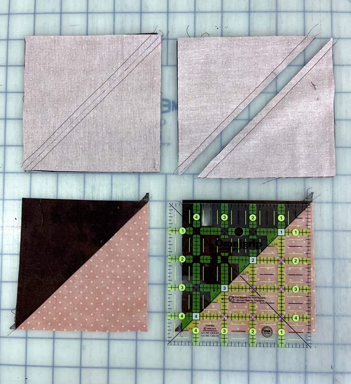 Half-square triangles that have been sewn and then trimmed using an Omnigrip 5" ruler