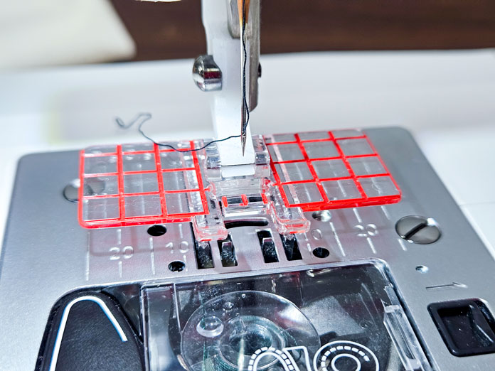 A clear plastic presser foot with red lines