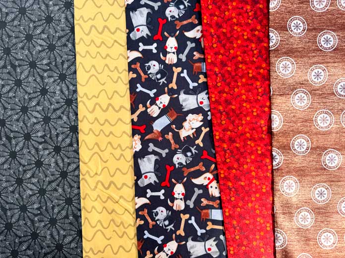 Bricks used in the quilt, black, yellow, a fabric with a dog theme, red and brown/tan fabrics.