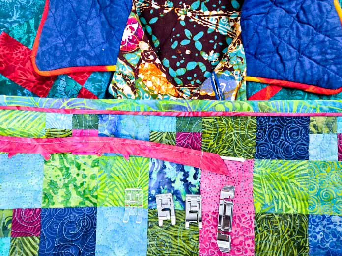 Bright colored quilts, jackets, with metal and plastic sewing machine feet