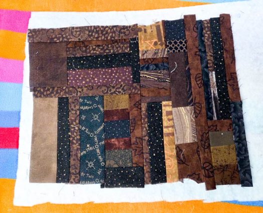 Scrappy brown fabric on white batting