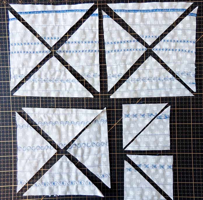 Overhead view of squares cut for the selvage project including 12 side and 4 corner triangles