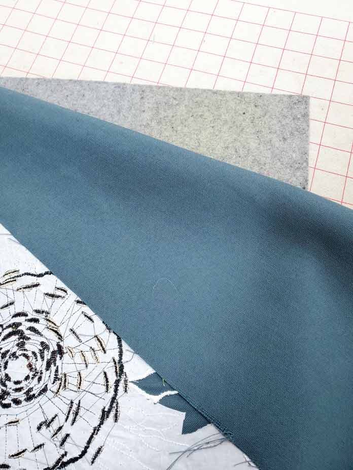 A machine embroidery design face down on a wool pressing mat. Husqvarna Viking Designer Sapphire 85, Inspira EZ Snip Curved Scissors