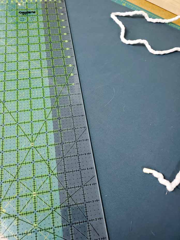 A large quilting ruler placed on a green fabric; Husqvarna Viking Designer Sapphire 85
