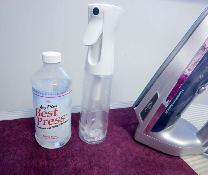 Mary Ellen’s Best Press refill bottle and Best Press spray and misting bottle sitting on wrinkled fabric