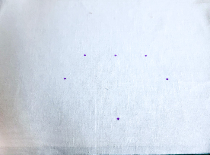 White fabric with six purple dots