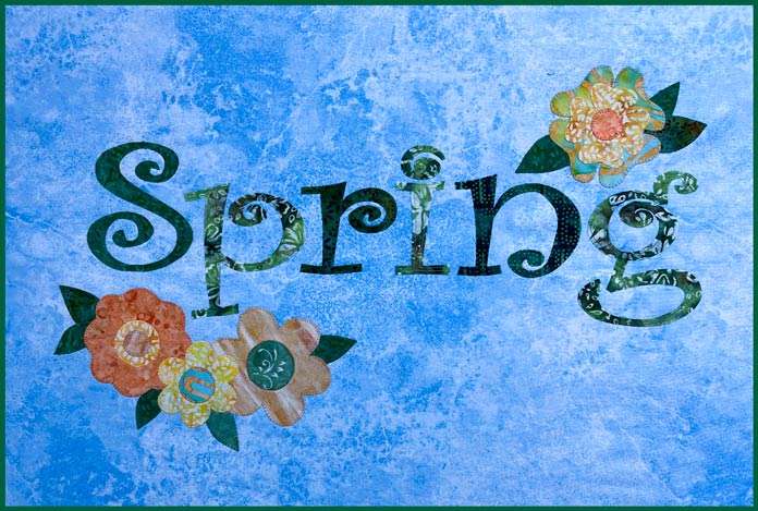 The word spring in various green colors on a blue and white fabric background