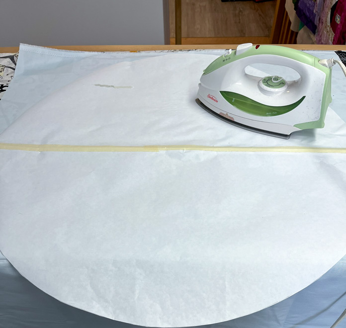 Ironing a circle of freezer paper shiny side down to the right side of light blue background/sky fabric