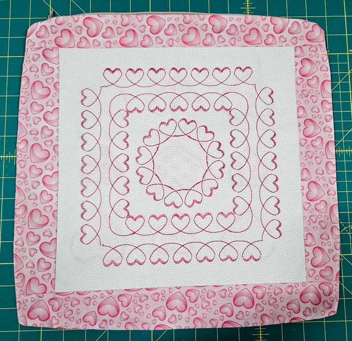 A pink and white cushion cover with hearts; machine embroidery, quilting, mySewnet, HUSQVARNA VIKING, embroidery software, digital embroidery, quilt block wizard, applique, embroidery design, monogramming; machine embroidery, quilting, mySewnet, HUSQVARNA VIKING, embroidery software, digital embroidery, quilt block wizard, applique, embroidery design, monogramming