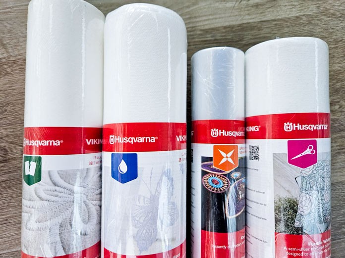 Four rolls of white fabric with red labeling