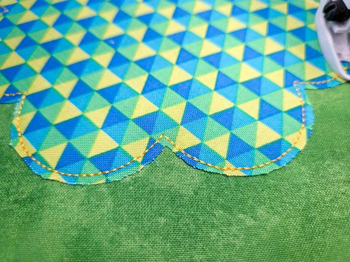 Yellow stitching on green, blue, and yellow fabric
