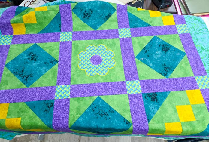 The quilt top on an ironing surface; Creativate Embroidery Software