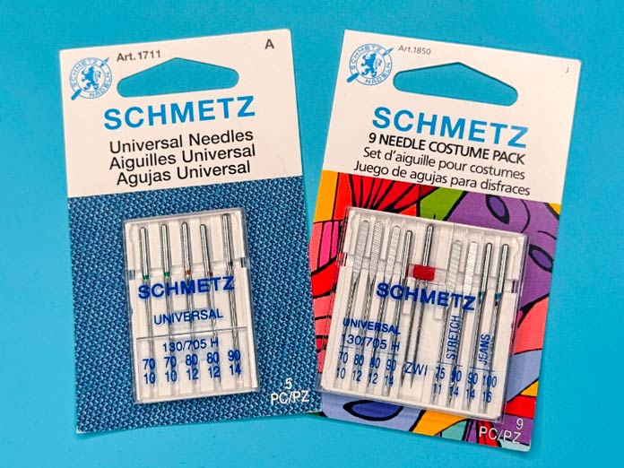 Multiple packages of assorted SCHMETZ Universal sewing machine needles and sizes.