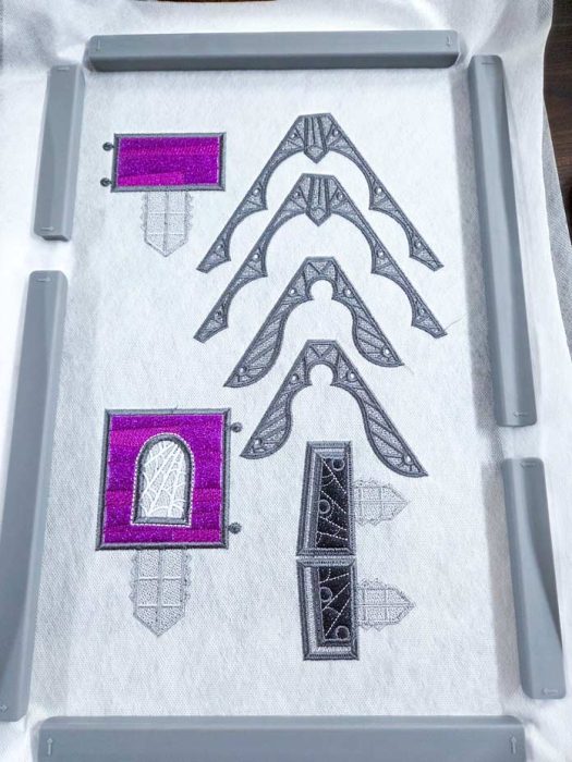 Pieces of grey and purple machine embroidery in an embroidery hoop