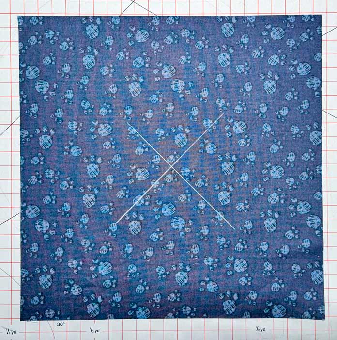 An X is drawn on each of the fabric squares that will be used to make the circles.