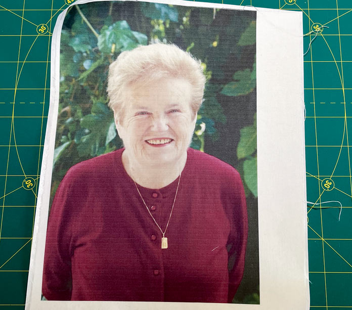 A photo of a smiling woman printed on white fabric; OLFA Square Rotating Cutting Mat