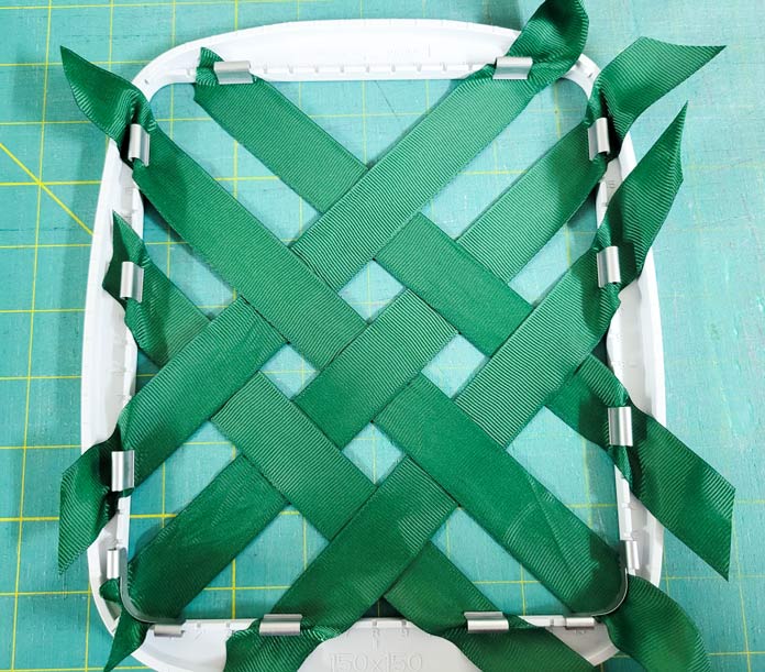 Green ribbons placed on the diagonal in a machine embroidery hoop; Husqvarna Viking Texture Hoop