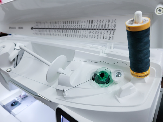 Green thread on a white sewing machine with a green bobbin; Husqvarna Viking Tribute 150C