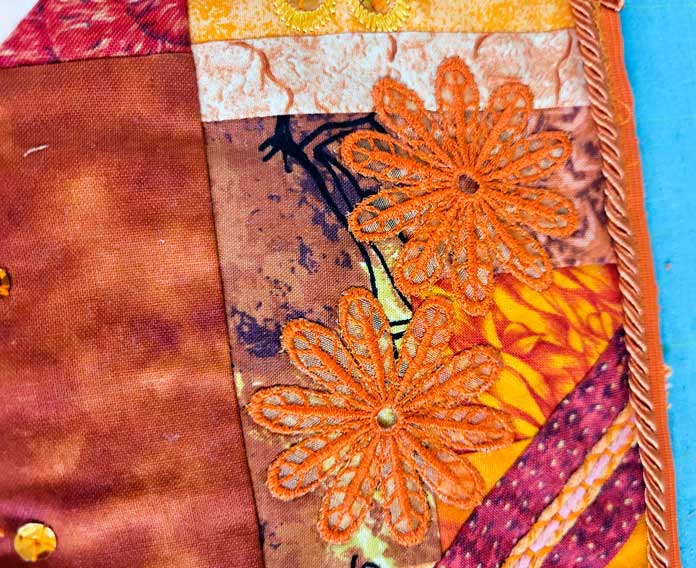 Orange applique flowers and orange cording stitched to an orange fabric