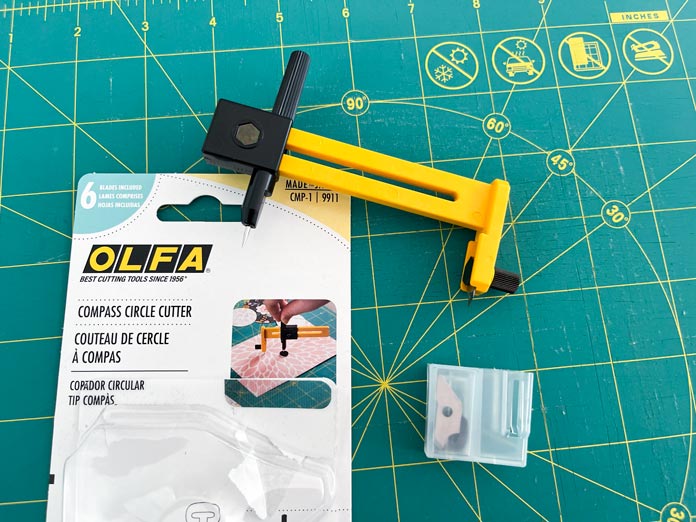 OLFA Compass circle cutter with six blades and an OLFA 12” rotating mat.