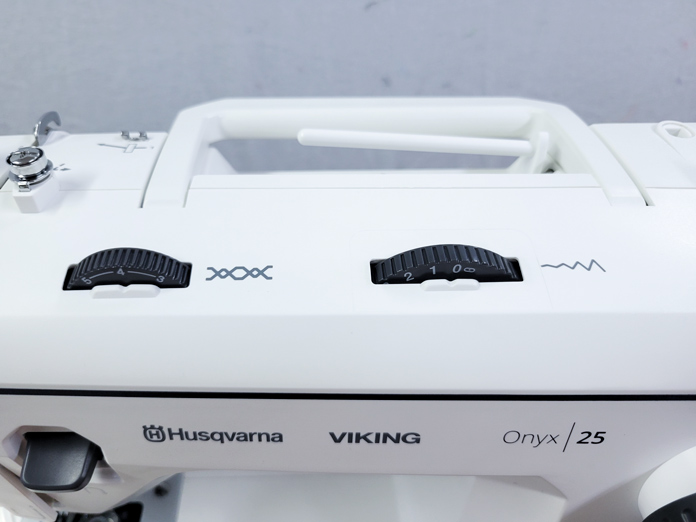 Two black dials on a white sewing machine; on the Husqvarna VIKING ONYX 25