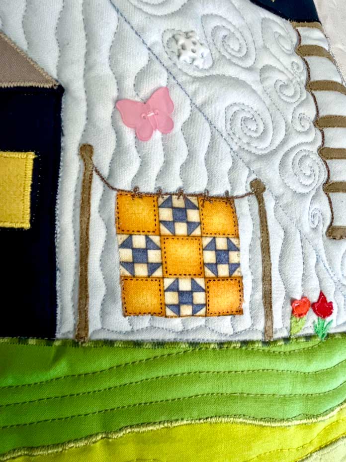 Picture of a part of the quilt with a mini quilt on a clothesline edge stitched with Gütermann Invisible Nylon Thread