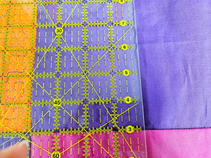 A quilter’s ruler on purple fabric