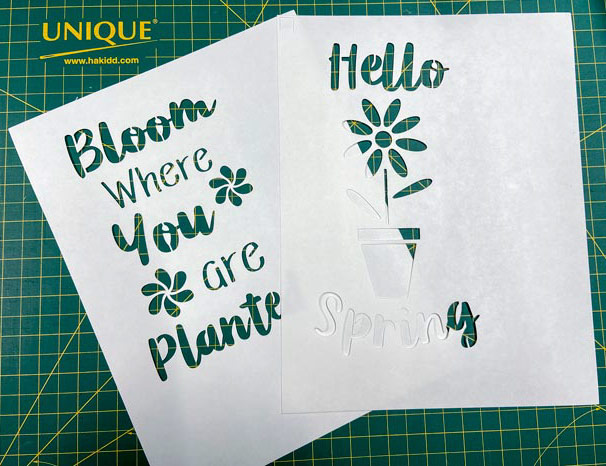 Two white freezer paper stencils are shown on top of a green cutting mat; Sew Easy Freezer Paper for Quilting and Applique